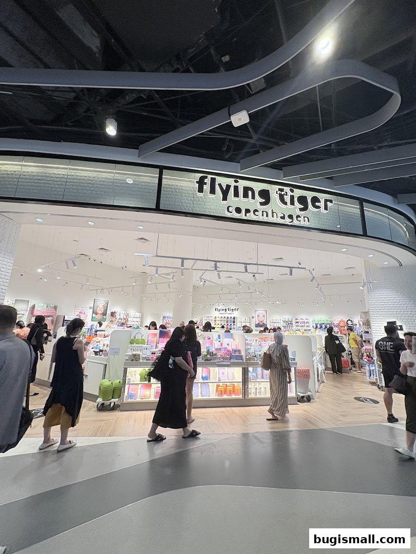 People browsing inside a brightly lit Flying Tiger Copenhagen store with colorful products on display.