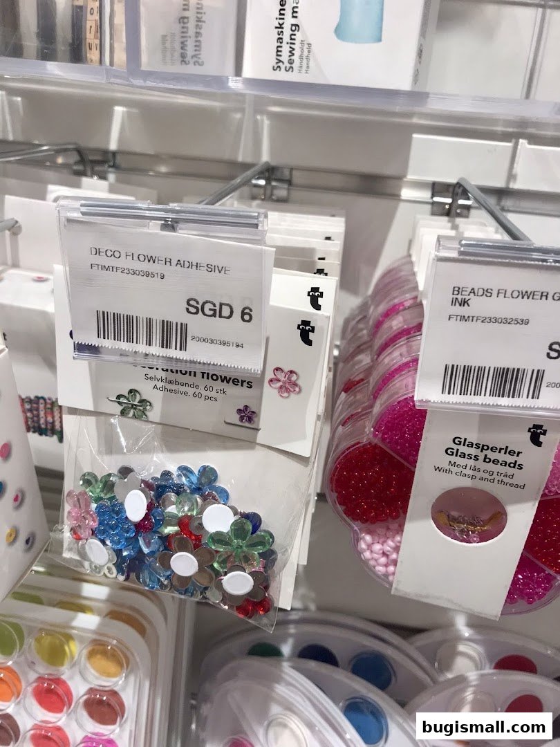 Close-up of craft supplies including flower stickers and glass beads on display.