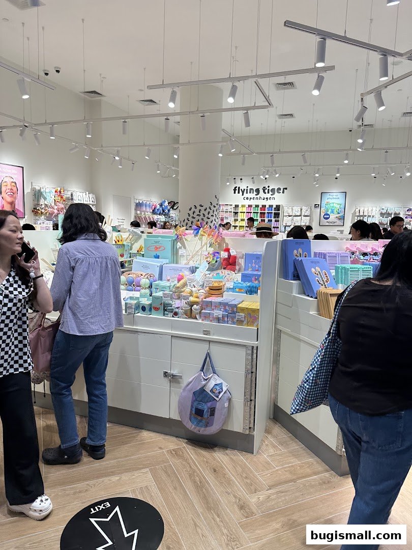 Interior view of a Flying Tiger Copenhagen store filled with colorful merchandise and shoppers.