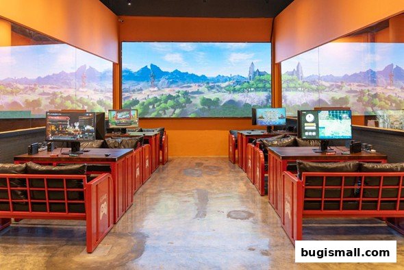 Interior of a gaming lounge with multiple computer stations and large screens displaying game landscapes.