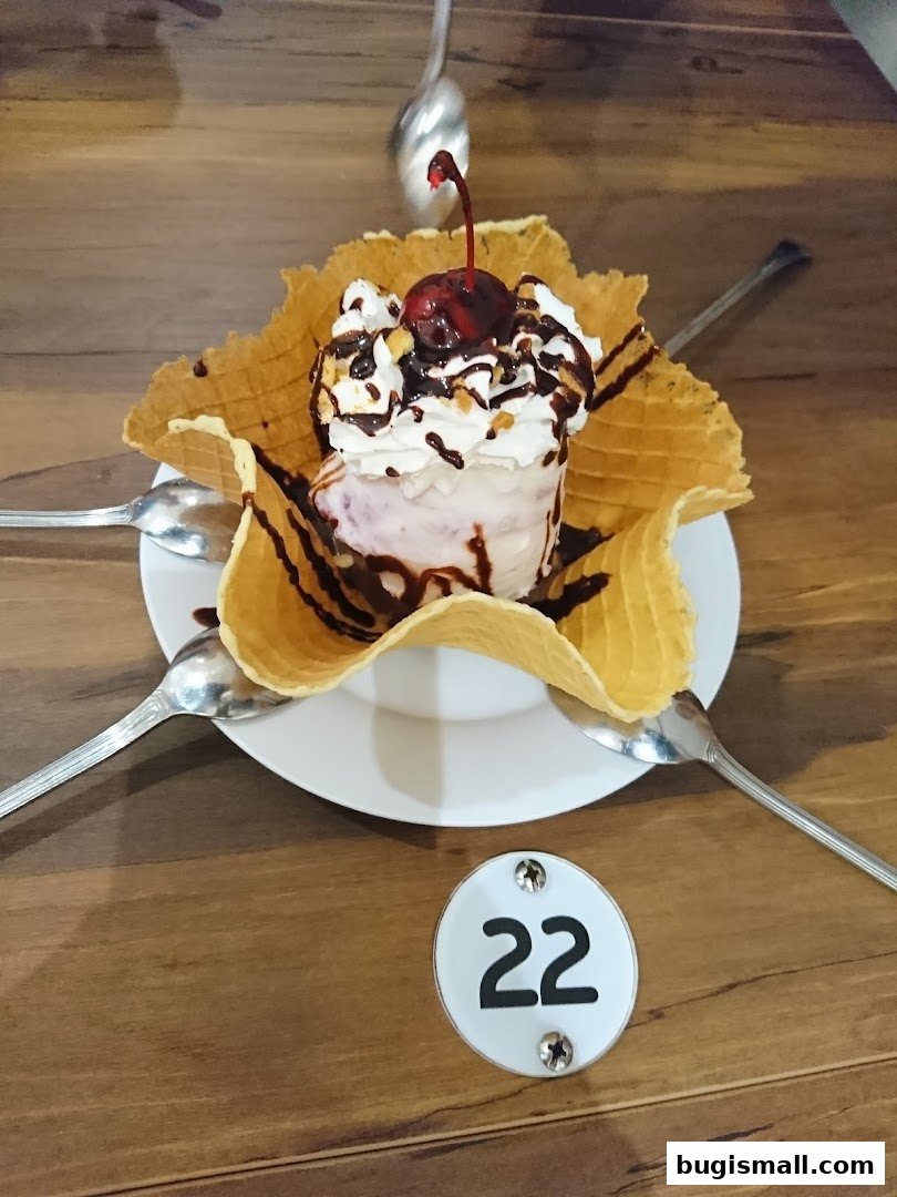 A delicious ice cream sundae served in a waffle bowl with whipped cream and a cherry.