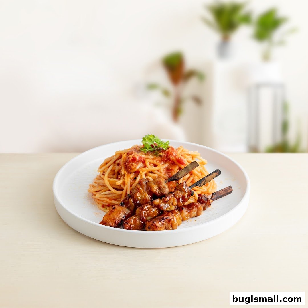 A white plate holds spaghetti with tomato sauce and grilled meat skewers.