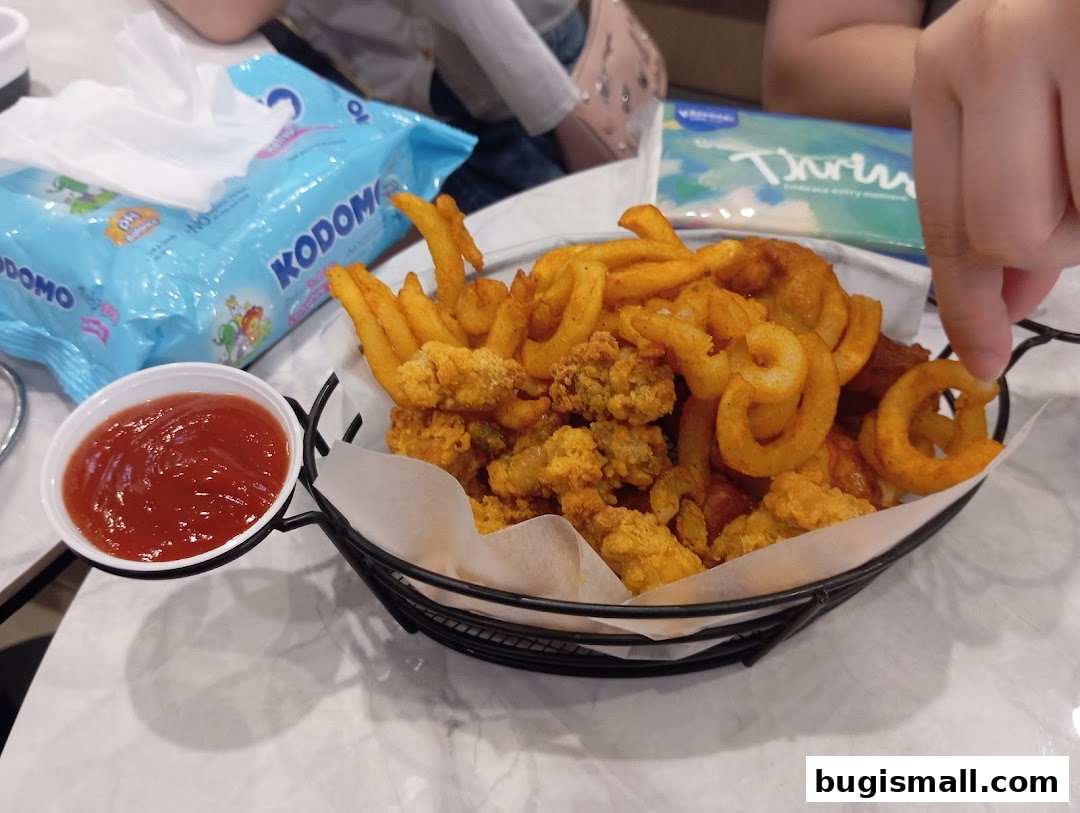 A basket of curly fries and fried chicken pieces with a side of ketchup.