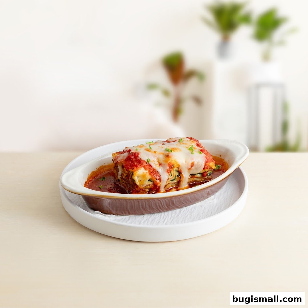 A delicious slice of lasagna topped with melted cheese and herbs, served in a dish.