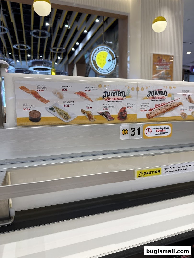 A conveyor belt sushi display featuring various sushi items and desserts with prices.