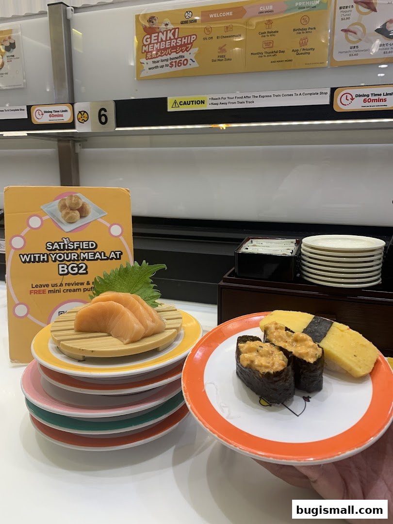 A hand holds a plate of sushi with salmon and tamagoyaki, with more sushi plates stacked nearby.