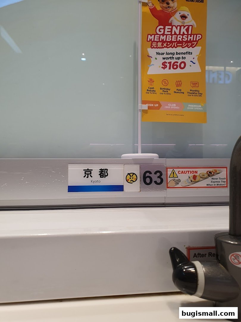A Genki Sushi membership promotion banner and a table number with a caution sign.
