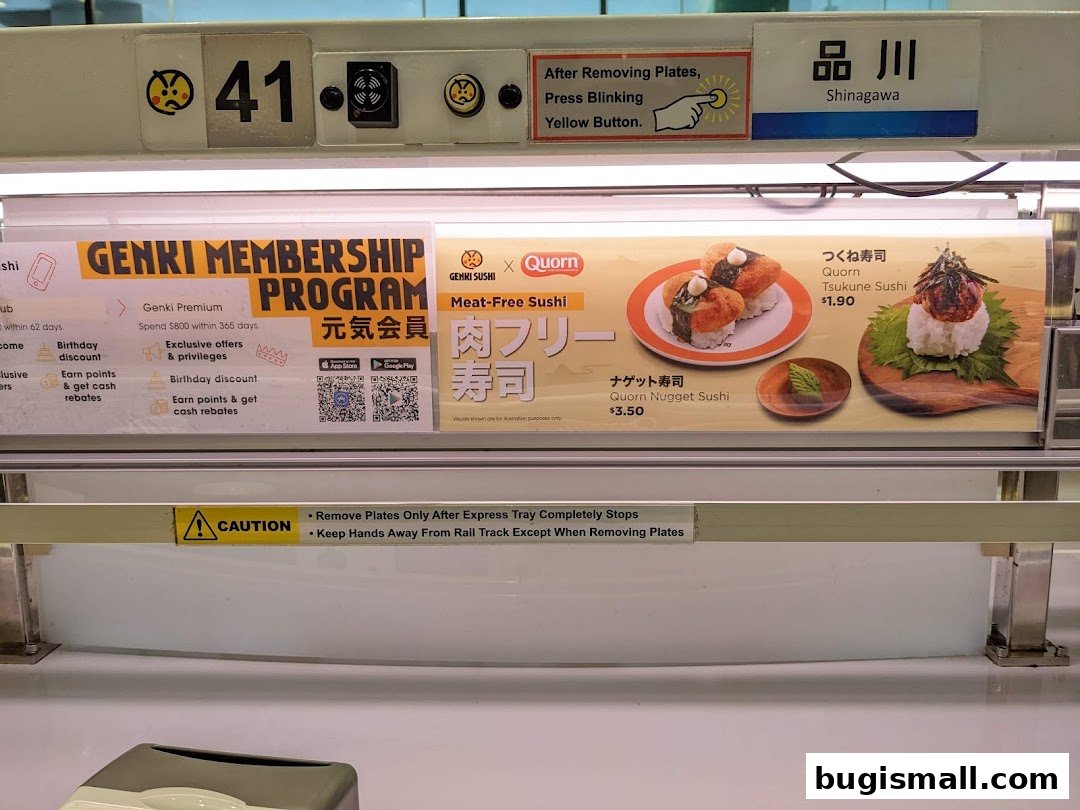 A display at Genki Sushi showing membership program and meat-free sushi options.