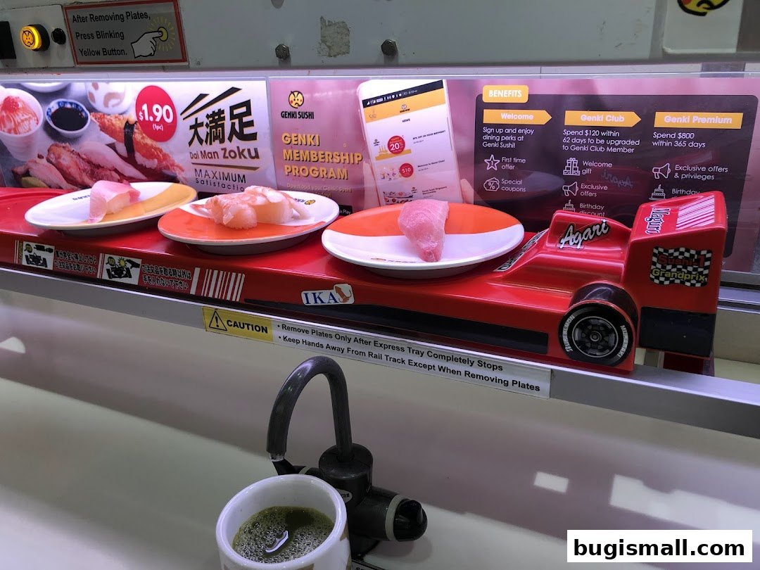 Sushi plates on a conveyor belt with a red race car and membership program information.