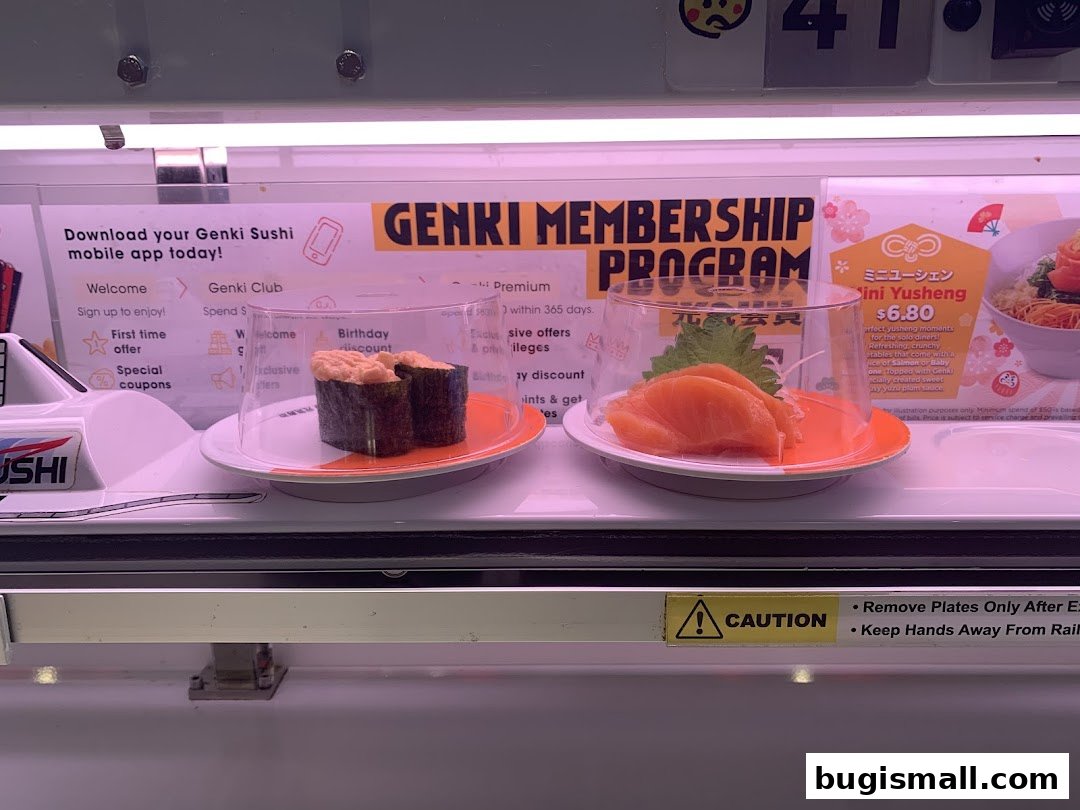 Sushi plates on a conveyor belt with promotional signs for a membership program.