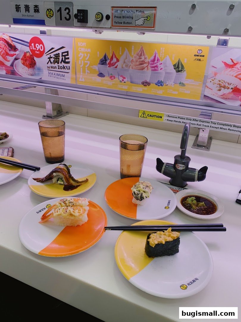 Conveyor belt sushi with various plates of sushi and drinks.