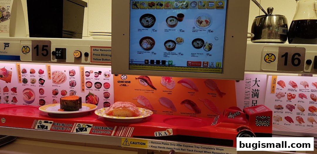 A conveyor belt sushi restaurant with various sushi dishes and a digital menu.