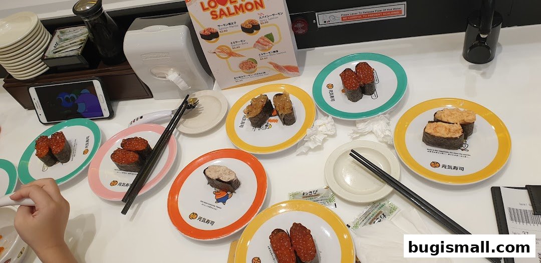 Plates of sushi on a conveyor belt with a menu and chopsticks.