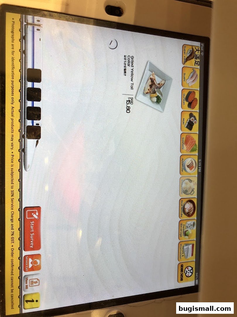 A tablet screen displaying a sushi menu with various categories and a grilled yellow tail dish.
