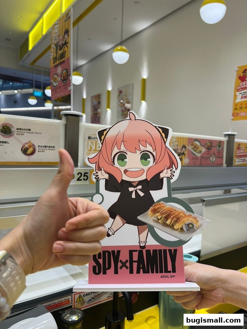 A thumbs-up gesture is shown next to a Spy x Family themed display with sushi.