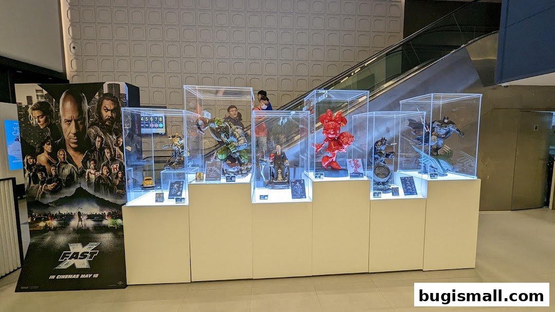 Display of collectible figures and movie posters in a cinema lobby.