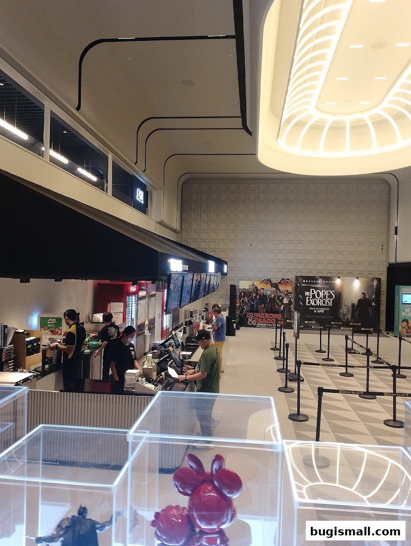 Interior view of a cinema lobby with ticket counters and movie posters.
