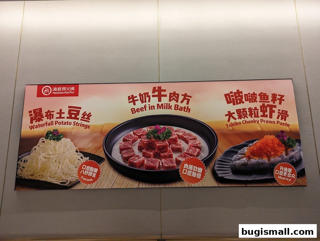 A sign showcasing three popular Haidilao hot pot dishes: Waterfall Potato Strings, Beef in Milk Bath, and Tobiko Chunky Prawn Paste.