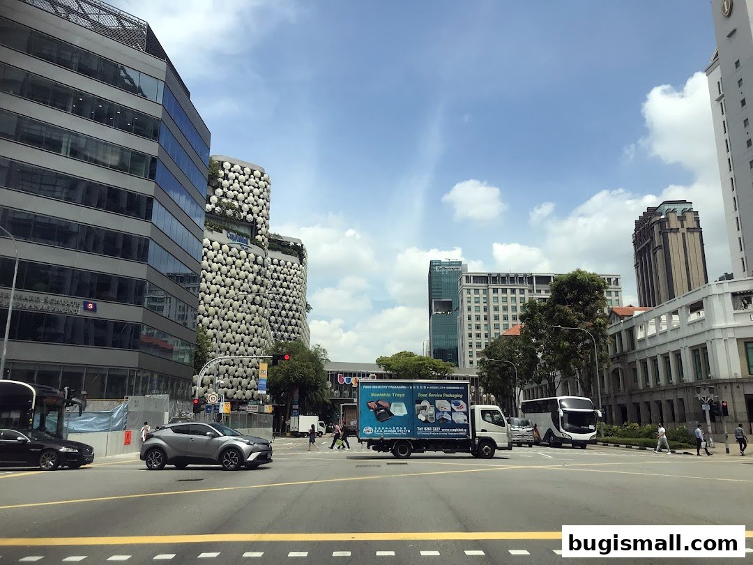A street view of a city intersection with modern buildings and traffic.