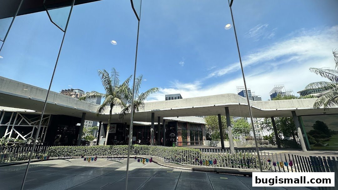 View of the Hardy Hardy Bugis shop front with palm trees and modern architecture.