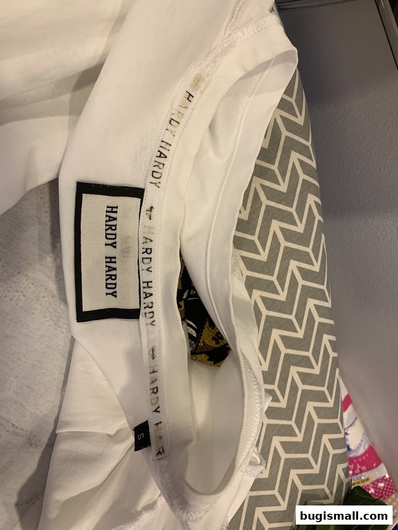 Close-up of a white Hardy Hardy t-shirt with brand labels and size tag.