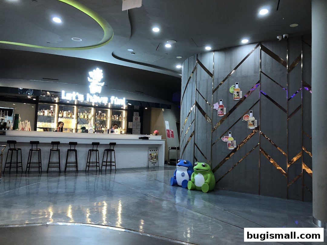 Interior of a karaoke bar with a bar, stools, and decorative wall elements.