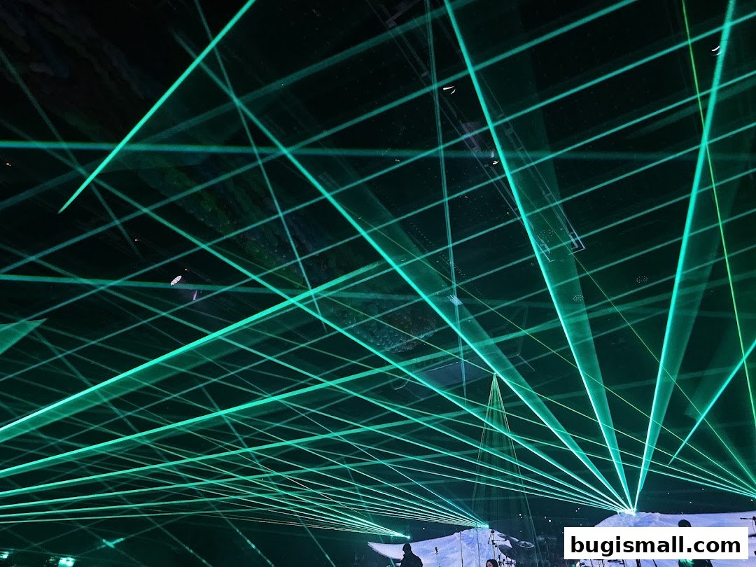 A dark venue filled with bright green laser beams crisscrossing the space.