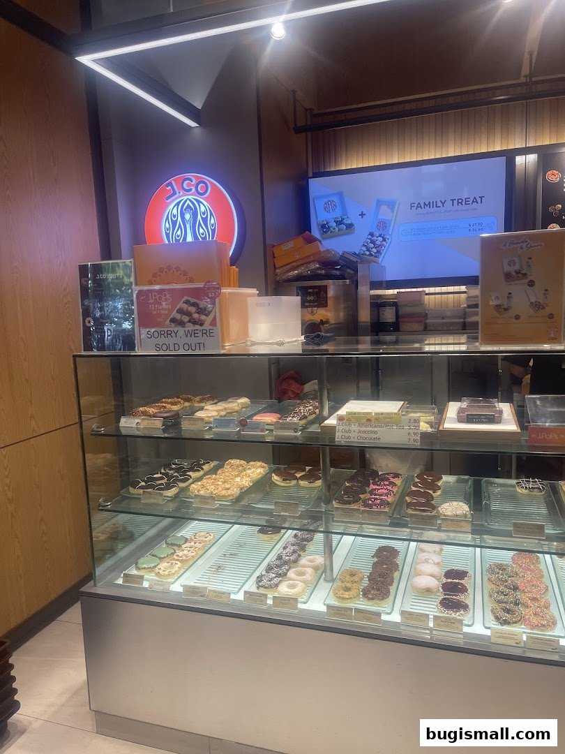 A display case filled with various colorful donuts at J.CO Donuts & Coffee.