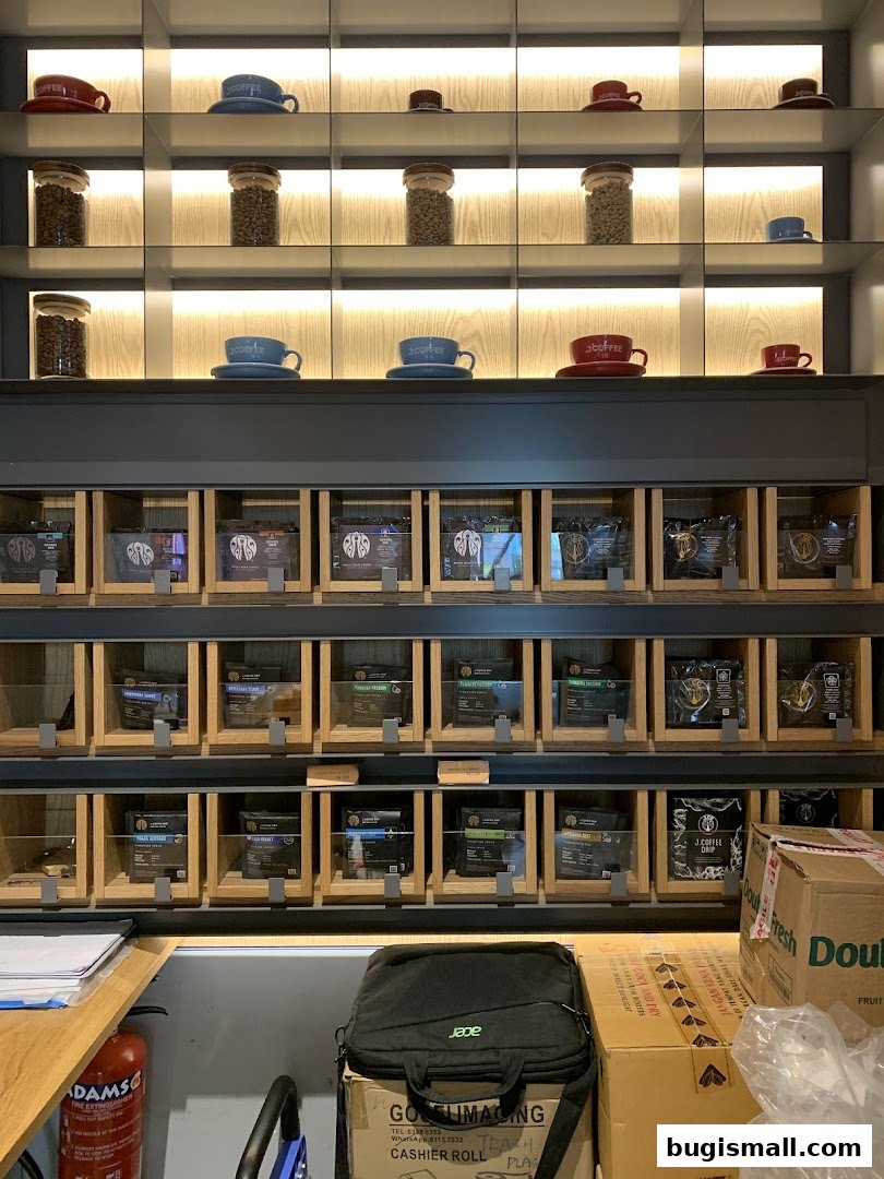 Shelves displaying coffee beans in jars and packaged coffee products at J.CO Donuts & Coffee.