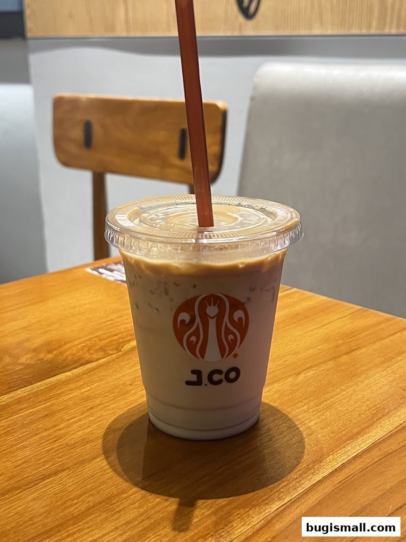 A close-up of an iced coffee with the J.CO Donuts & Coffee logo on the cup.