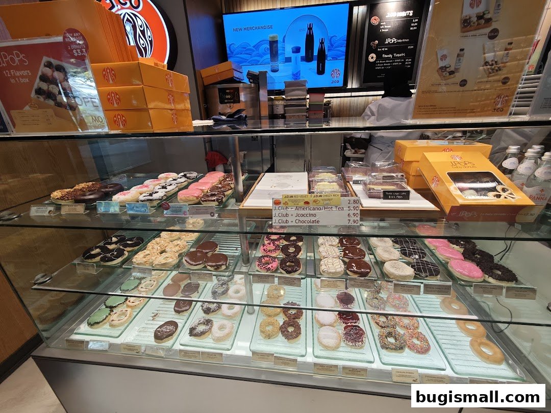 A display case filled with a variety of colorful donuts and pastries at J.CO Donuts & Coffee.