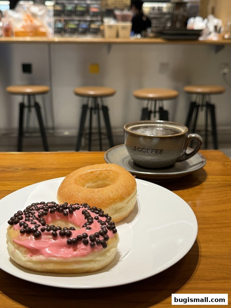 Two donuts and a cup of coffee on a table at J.CO Donuts & Coffee.