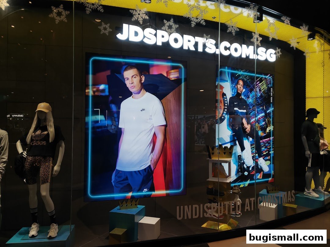JD Sports storefront window display featuring mannequins and digital screens with models.