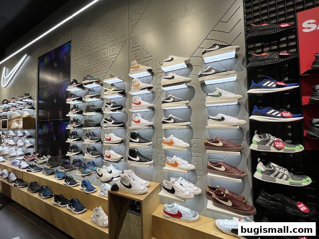 A wide selection of athletic shoes displayed on shelves and stands in a retail store.