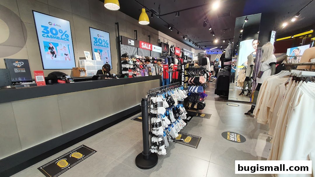 Interior view of JD Sports store with merchandise displays and a checkout counter.