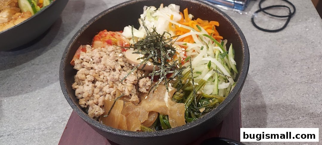 A close-up of a Korean bibimbap dish with minced meat, vegetables, and egg.