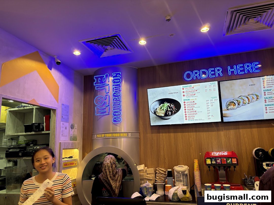 Interior of a JINJJA Chicken restaurant with a menu board and staff.