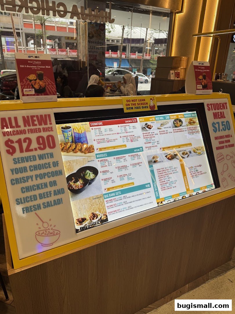 A digital menu board displaying Korean fried chicken and other dishes with prices.
