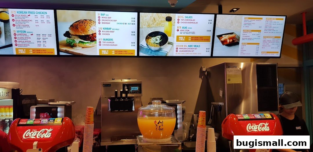 Digital menu board displaying Korean fried chicken, noodles, rice dishes, burgers, salads, stews, and kids' meals.