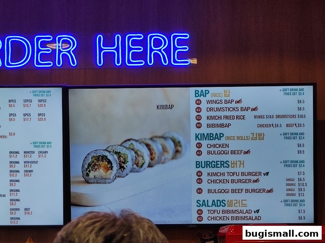 A menu board for JINJJA Chicken with Korean dishes like Bap, Kimbap, Burgers, and Salads.