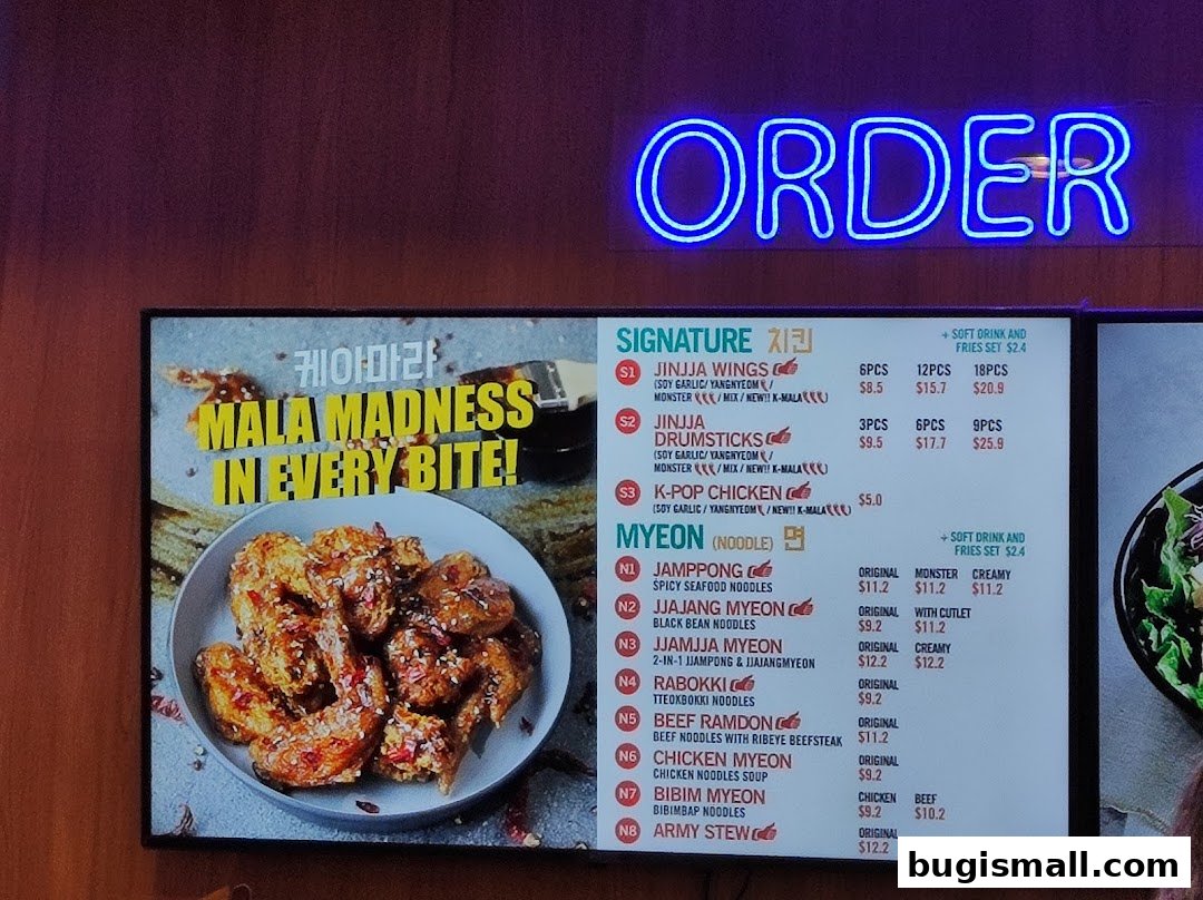 A digital menu board displaying Korean fried chicken and noodle dishes with prices.