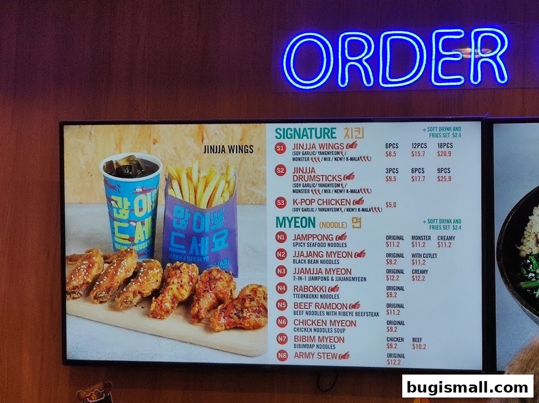 A menu board displaying Jinjja Chicken's signature wings, drumsticks, k-pop chicken, and various noodle dishes.