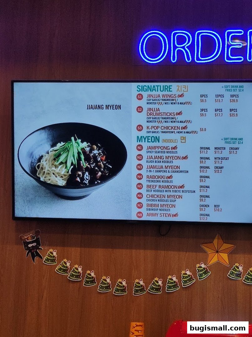 A menu board for JINJJA Chicken featuring Korean fried chicken and noodle dishes.