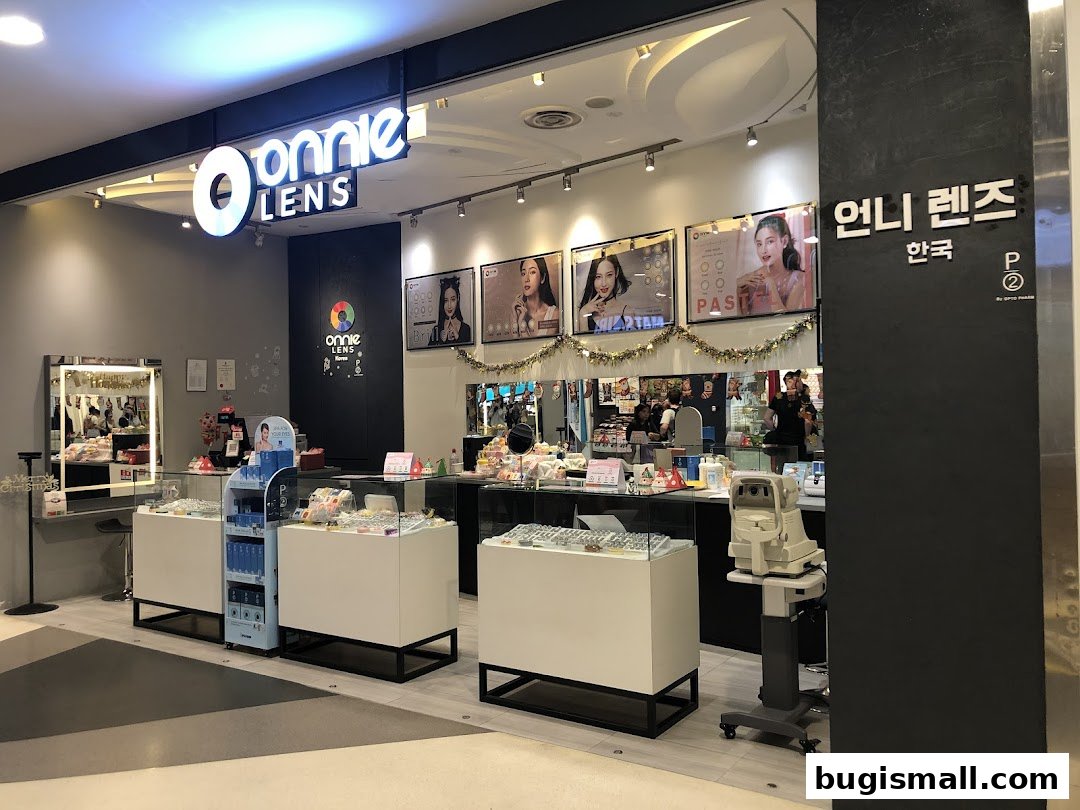 The exterior of a modern optical shop with displays of contact lenses and eye care products.