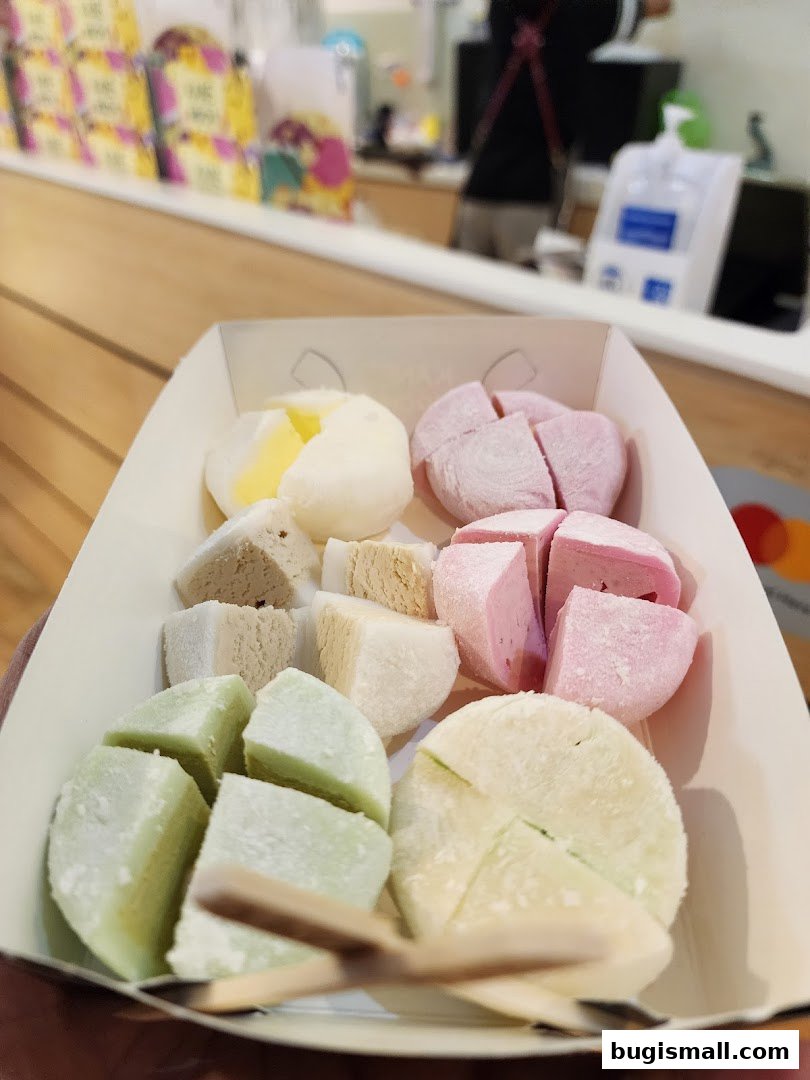 A tray of colorful mochi desserts, some cut in half, ready to be enjoyed.