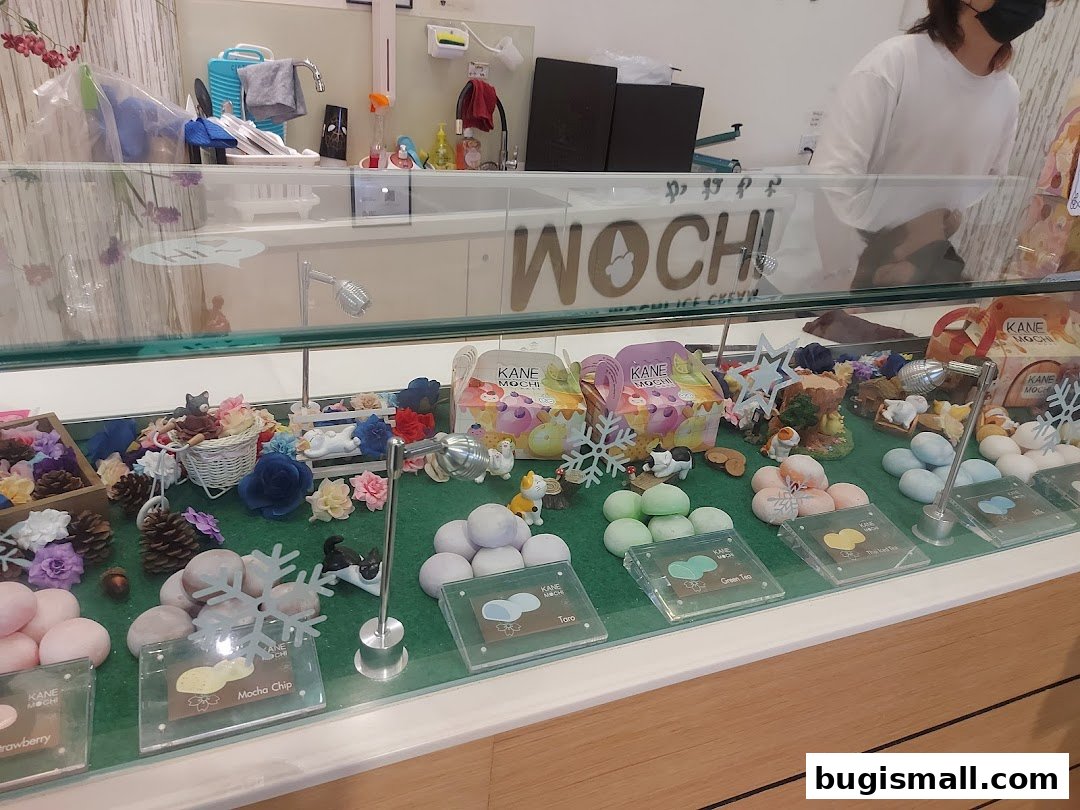 A display case filled with colorful mochi ice cream flavors and decorative elements.