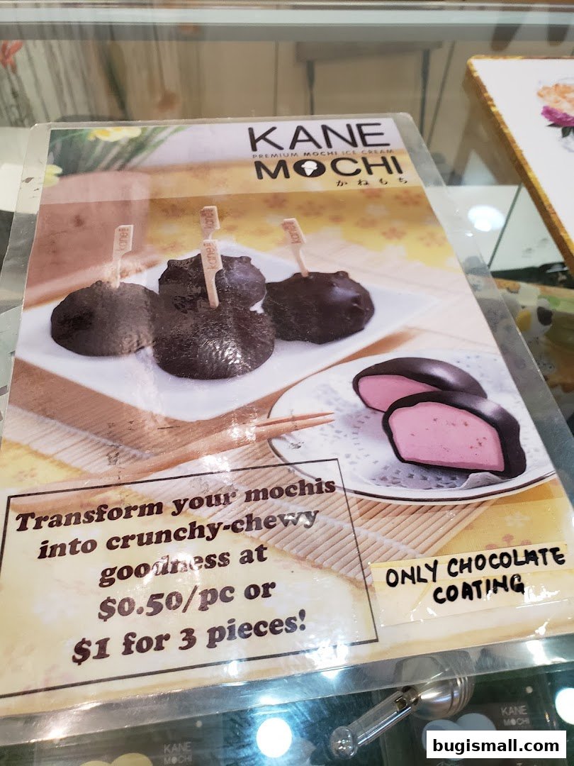 A menu board for Kane Mochi, showcasing chocolate-coated mochi ice cream with pricing.