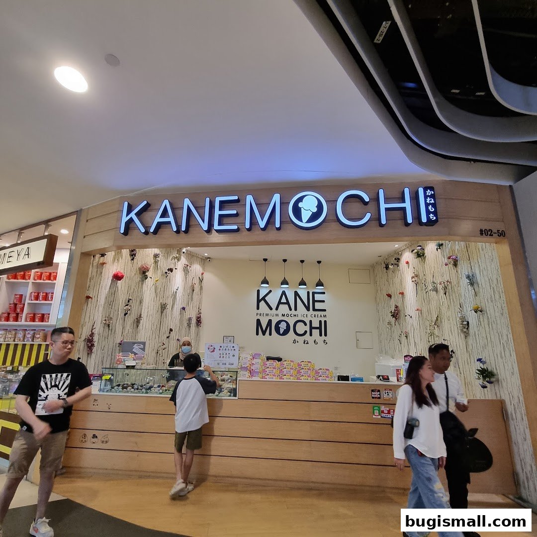 The Kane Mochi shop front with illuminated signage and customers at the counter.