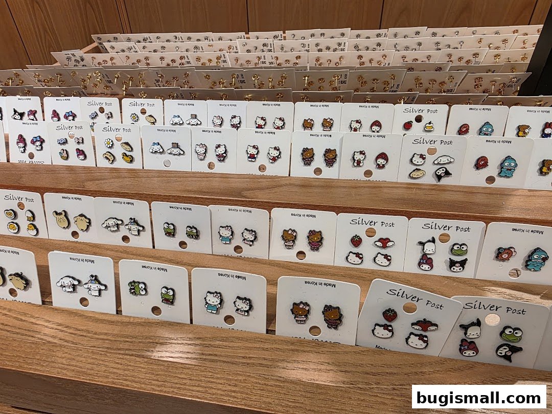 A display of various cute character-themed earrings, neatly arranged on shelves.