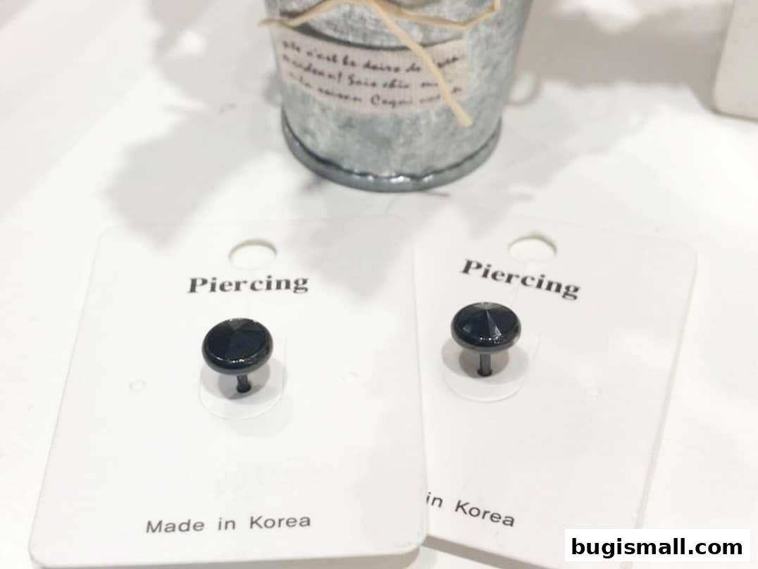 Two black stud earrings with faceted gems, labeled 'Piercing' and 'Made in Korea'.